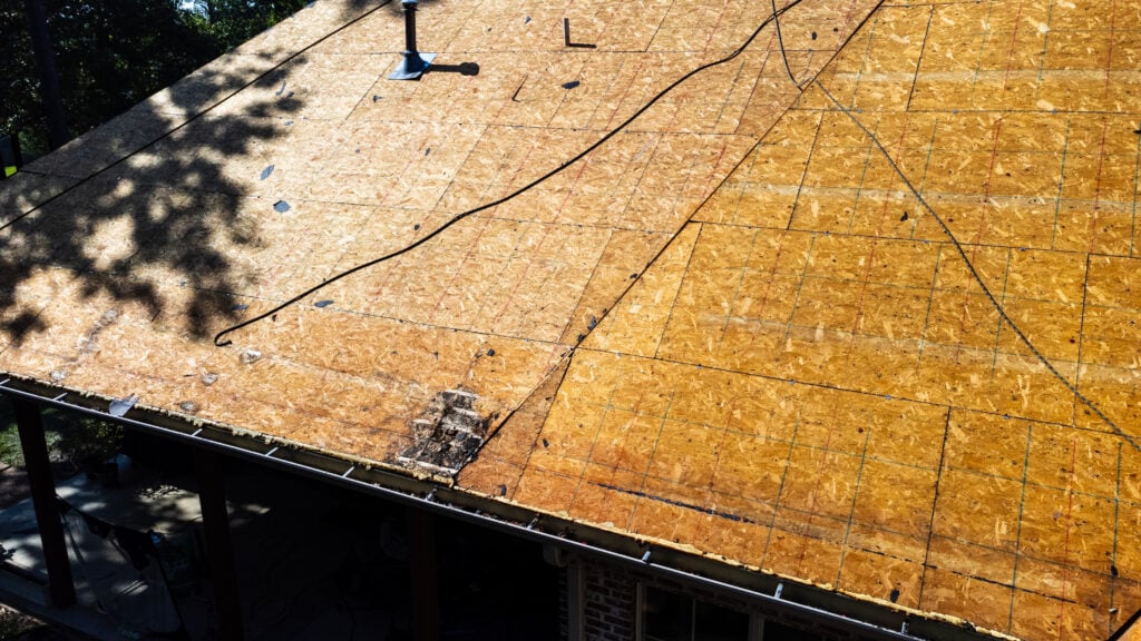 Roof of house in process of being replaced with deck boards.