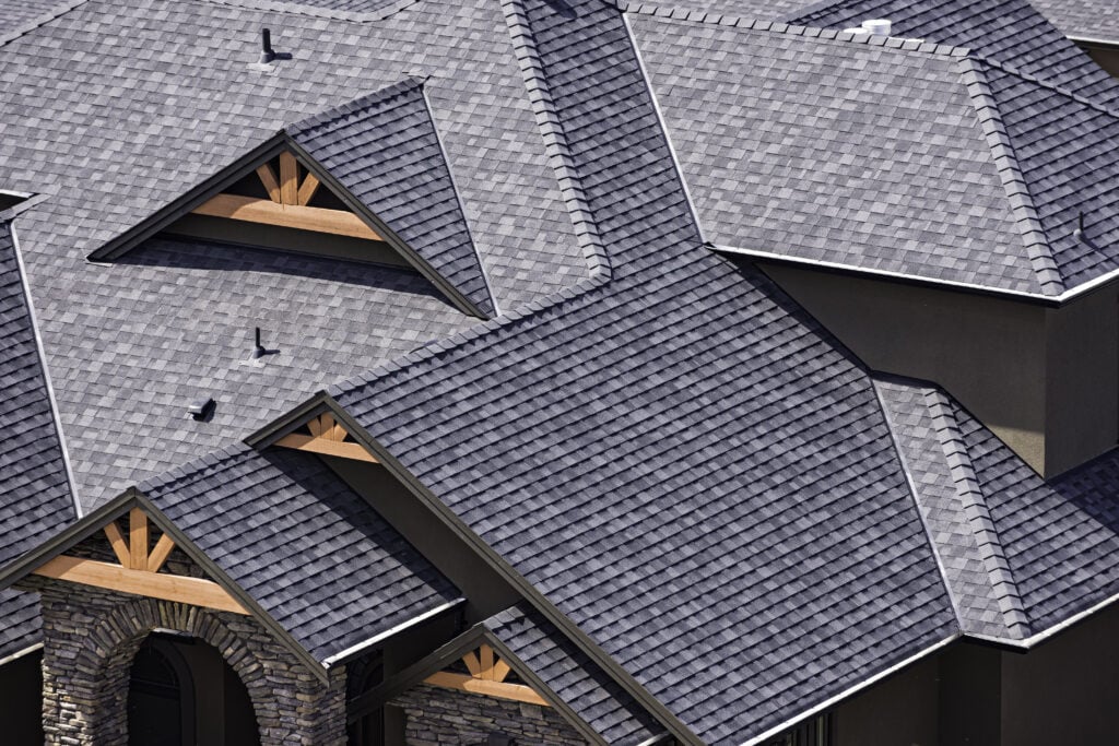 architectural shingles vs 3 tab Rooftop in a newly constructed subdivision in Kelowna British Columbia Canada showing asphalt shingles and multiple roof lines