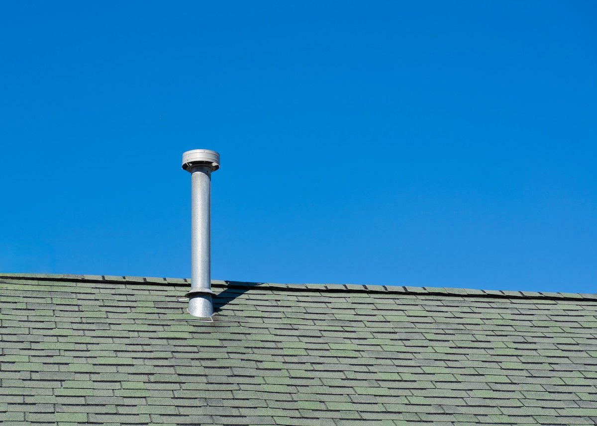 Metal vent pipe on shingled roof under clear blue sky in Boston, USA