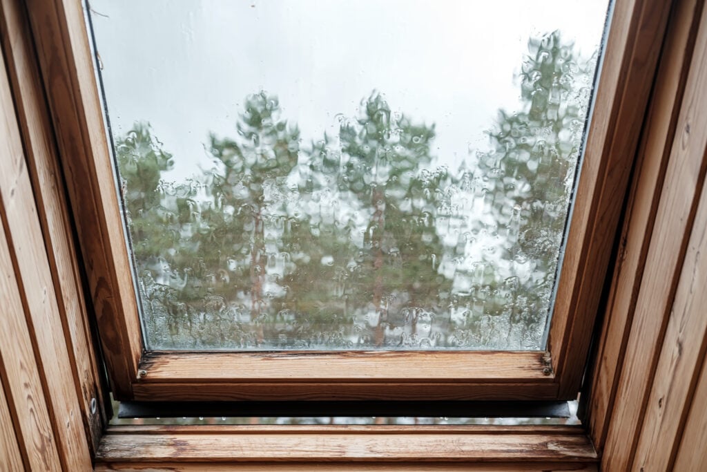  roof window in the attic, with raindrops dripping down the glass.