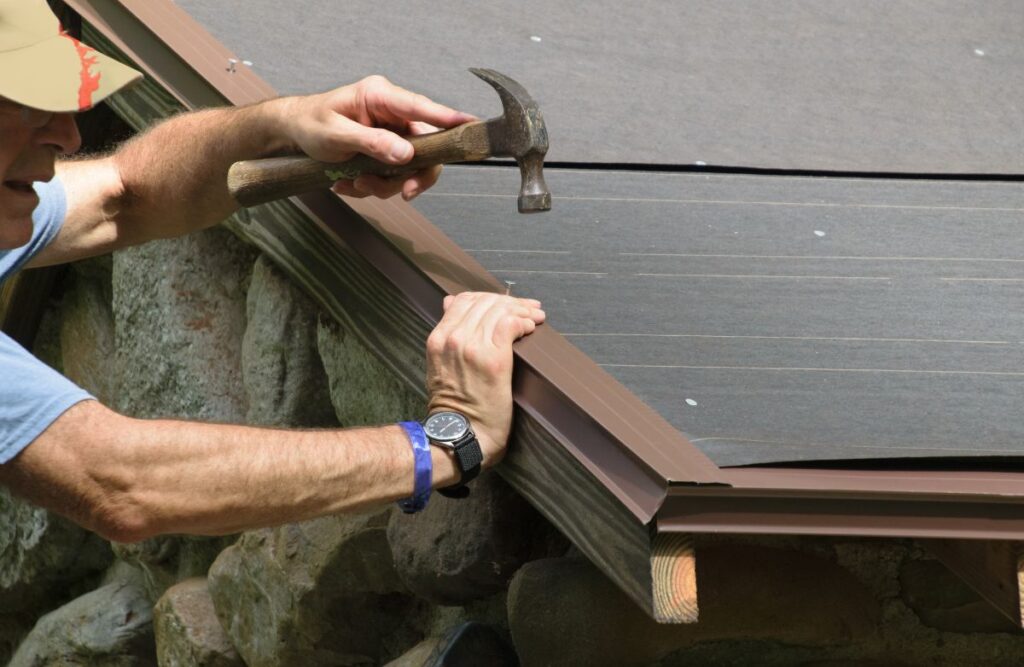 installing drip edge on existing roof worker using hammer to install