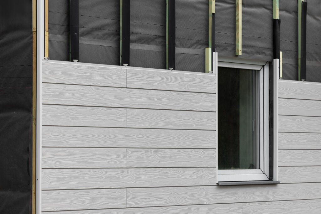 composite siding wood texture composite cladding installation on house facade. WPC exterior wall panels
